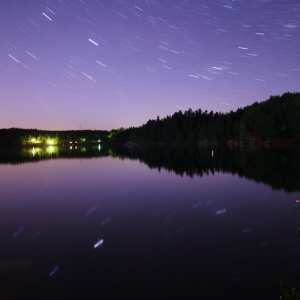 Sterne (Sternbild Fuhrmann) über dem Ottensteiner Stausee, Waldviertel mit Spiegelung der Sterne im See